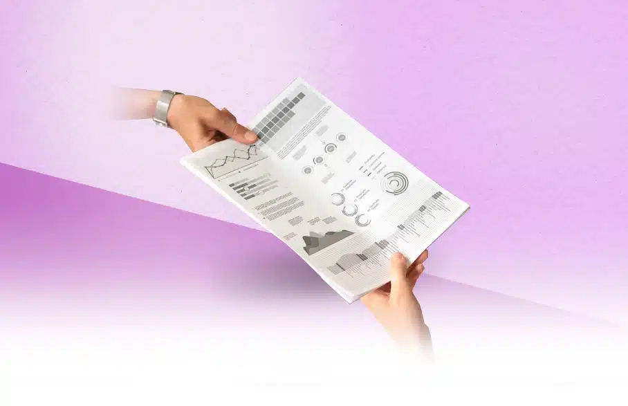שתי ידיים מעבירות מסמך עם תרשימים וגרפים.