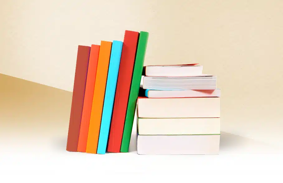 ספרים צבעוניים עומדים לצד ערימת ספרים.